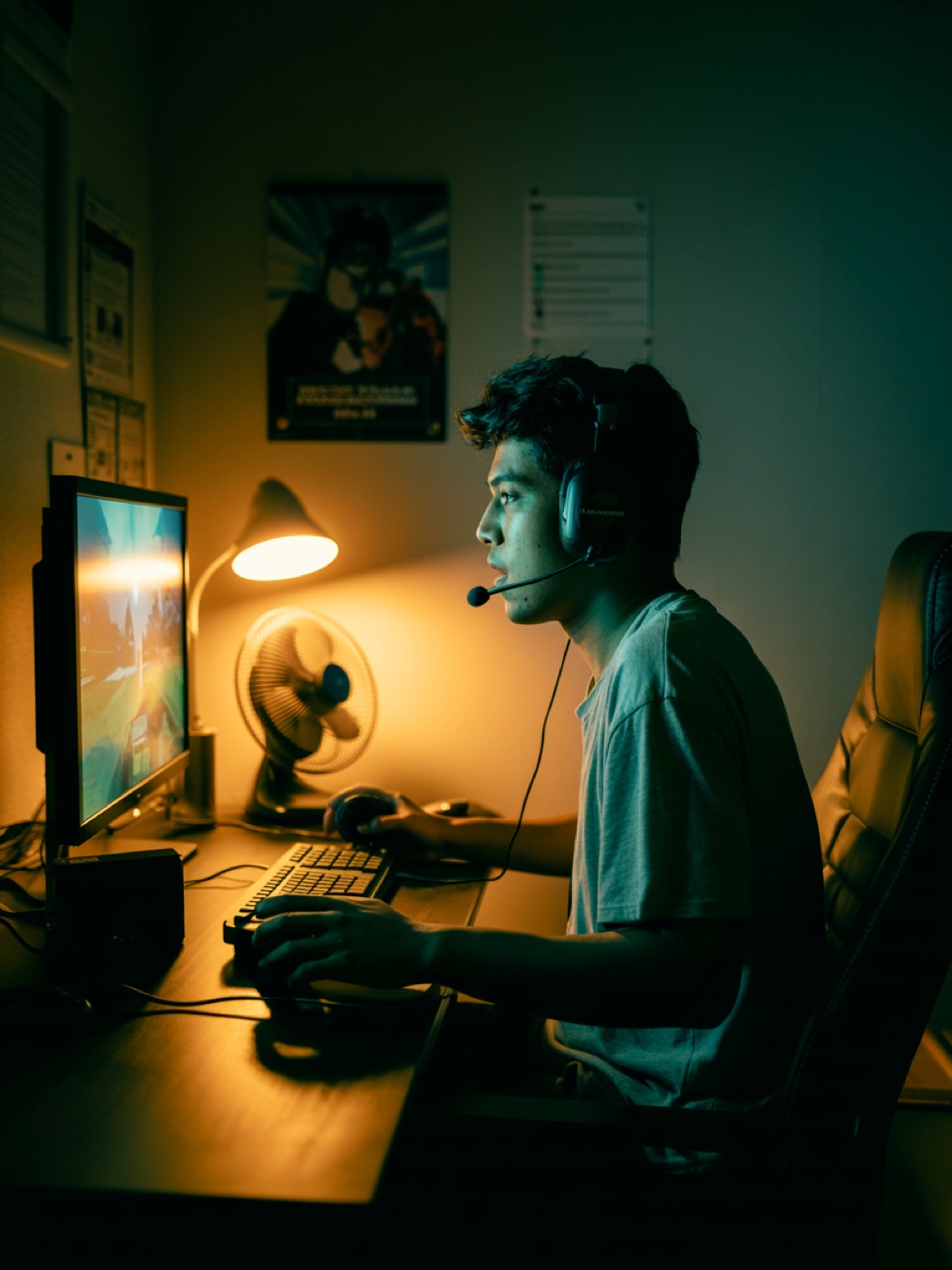 Un joven de Escuinapa jugando de noche, la cara iluminada solo por la pantalla.